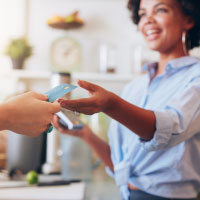 A customer handing the cashier their credit card.