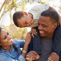 Two parents and their child having fun outside on a nice day.